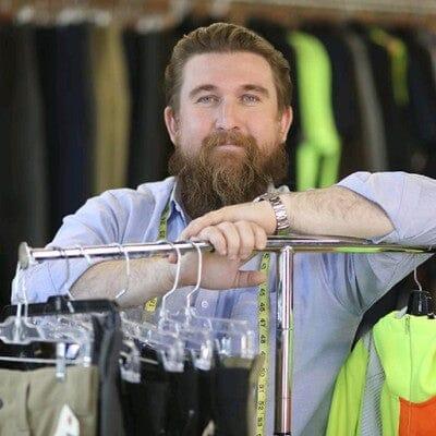 CEO Ted DeInnocentis stands at a rack of pants