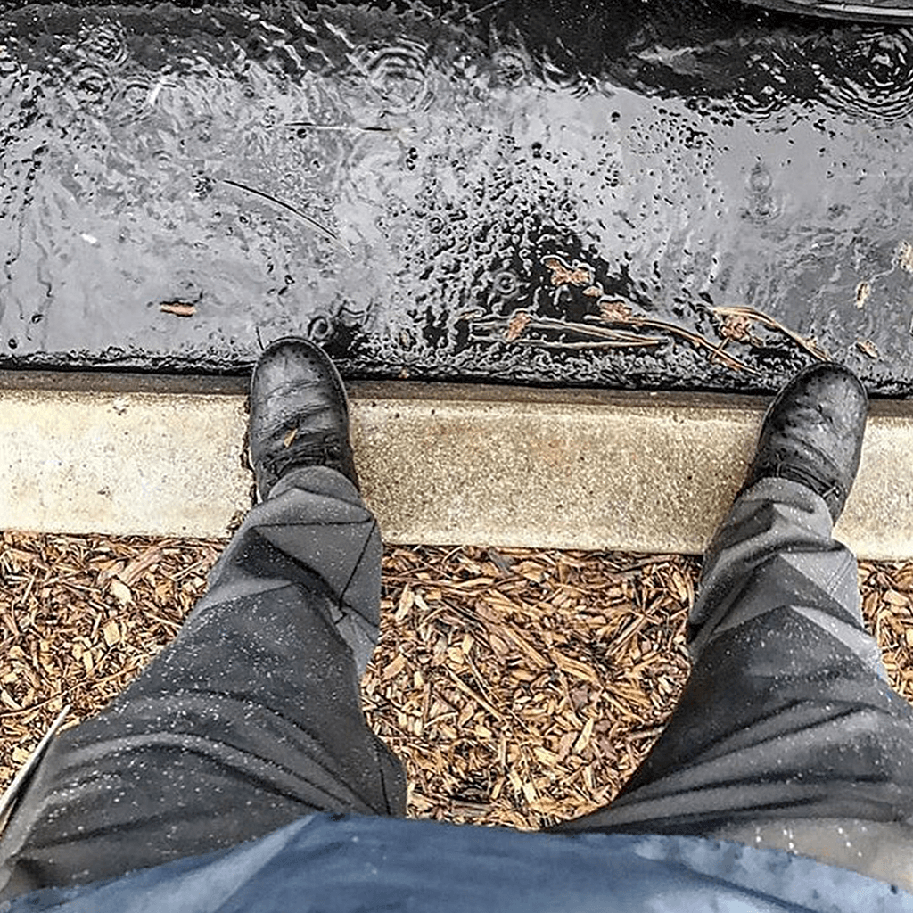 Black 1620 Shop Pant in the rain featuring DWR Water Repellent Finish